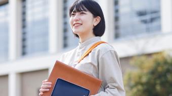 書類を持っている笑顔の女性のイメージ画像